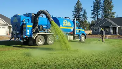 Hydroseeder truck spraying green slurry for new lawn installation in Spokane, WA
